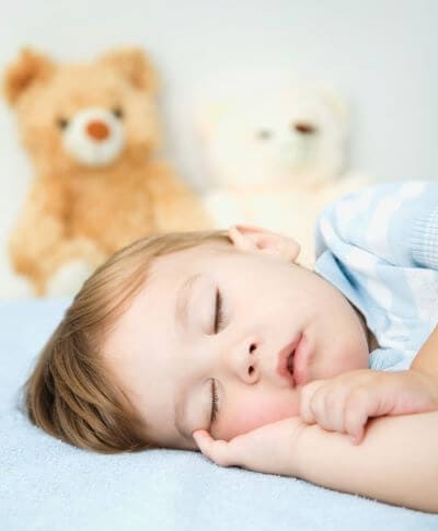 Toddler sleeping peacefully with a stuffed toy next to them providing comfort and security to help with fears and separation anxiety