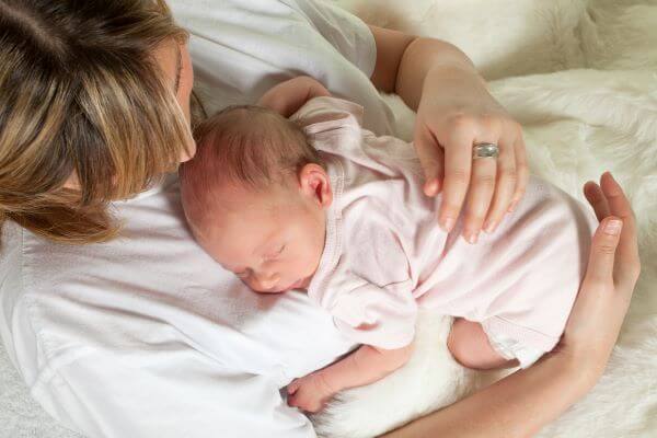newborn baby asleep on her mothers chest after a bedtime false start
