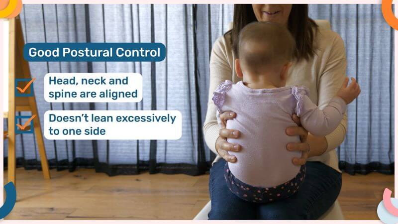 Emma Hubbard holding a baby on her lap, supporting her sides with her hands. Baby is sitting upright, with her spine, neck and head aligned. Text on the image explaing that good postural control is demonstrated by head, neck and spinal alignment and not leaning excessively.